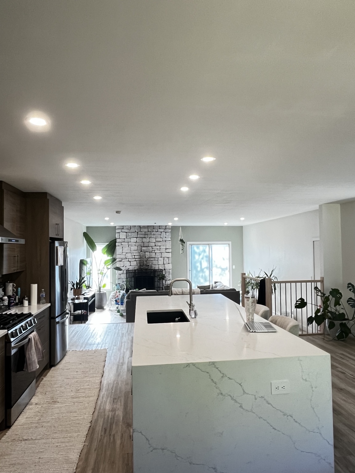 Open-concept kitchen with waterfall island and recessed lighting